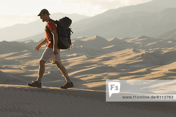 Man hiking in sand dunes  Colorado.