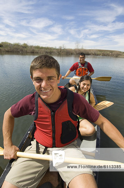 Teenagers canoeing in a river.