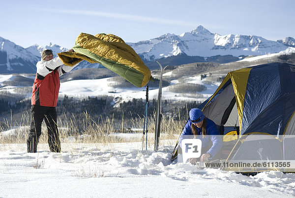Man boiling water near tent.