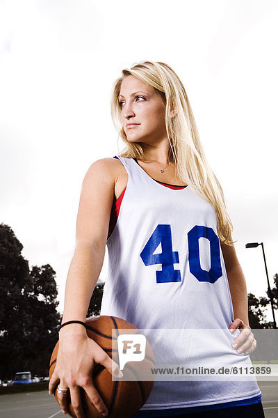 A portrait of an athletic woman playing basketball.