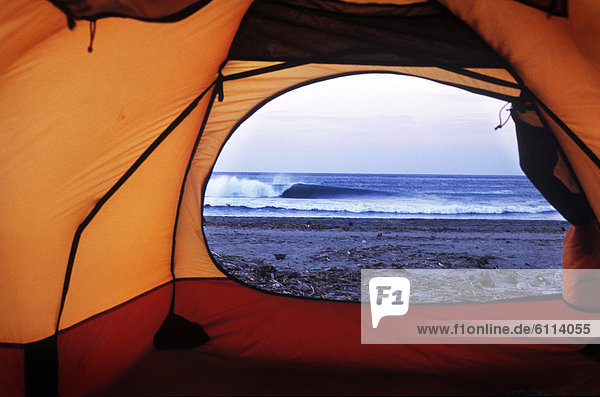 A view from inside a tent looking at a breaking wave in Michoacan  Mexico.