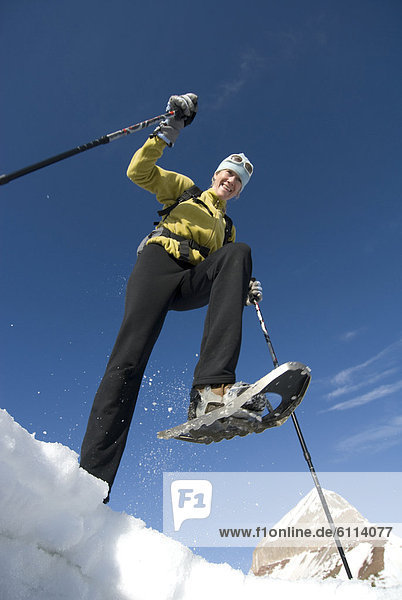 Woman snowshoeing below mountain  San Juan National Forest  Colorado.
