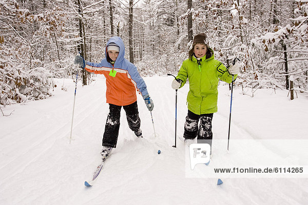 Two young girls Cross Country Skiing in Dayton  Maine.