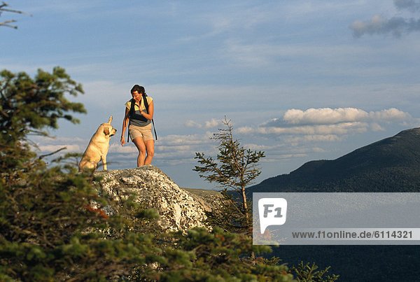 A woman and a dog on a mountain top  Newry  Maine.