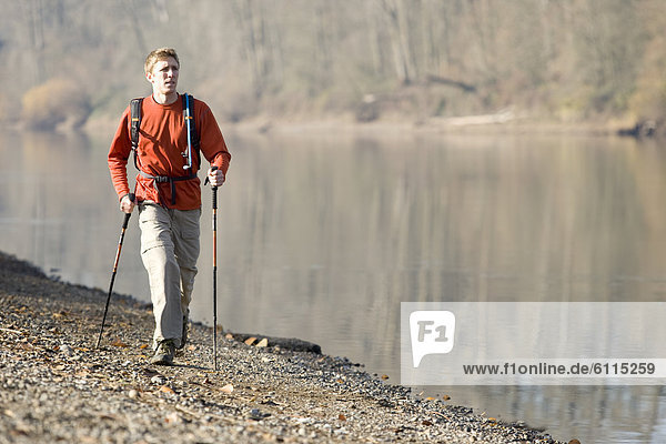 A man hiking along the banks of a river.