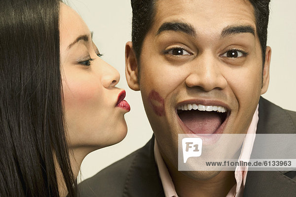 Portrait of woman kissing boyfriend on cheek mouth