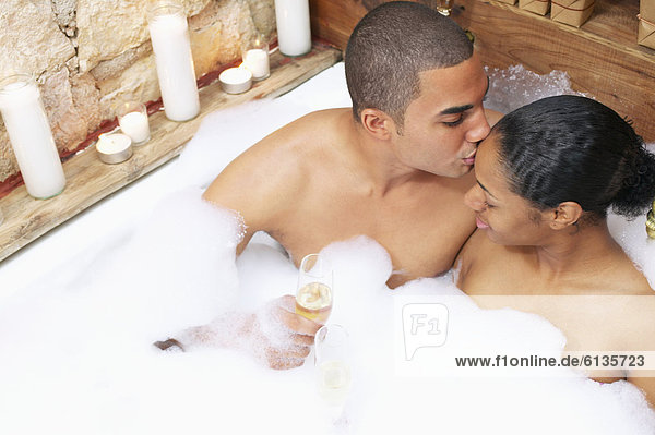 Couple kissing in bubble bath
