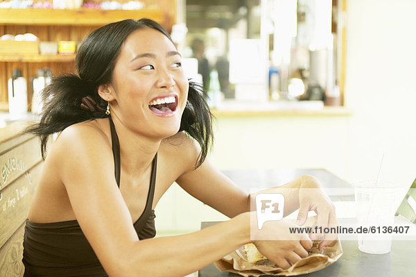 Teenage girl eating sandwich in cafe