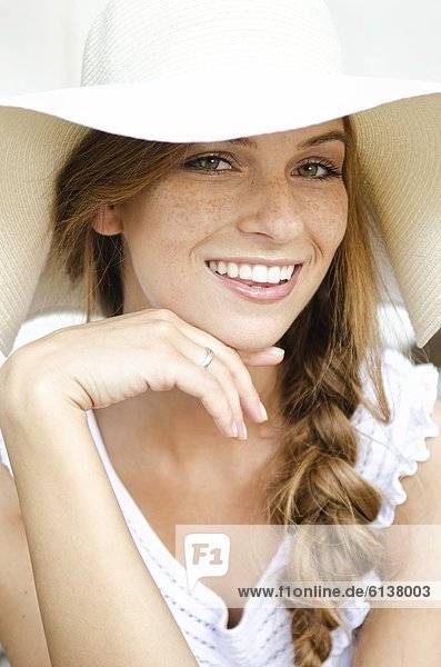 Lächelnde junge Frau mit Sonnenhut  Portrait