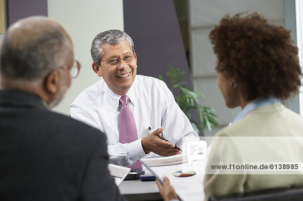 Businessman talking to man and woman