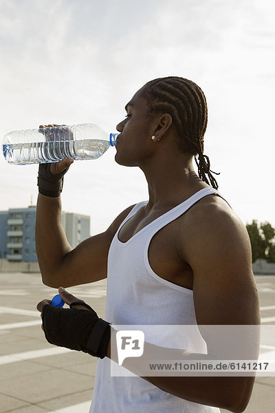 Athlete drinking water on city street