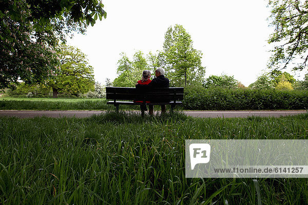 Older couple sitting on park bench