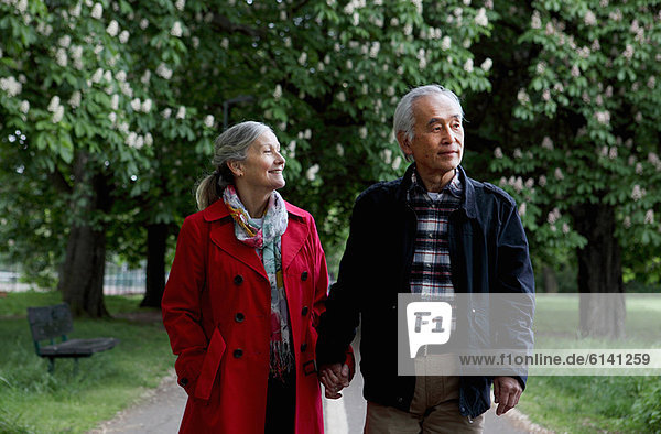 Older couple walking in park