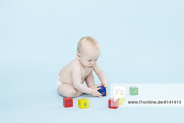 Baby Boy spielt mit farbigen Blöcken