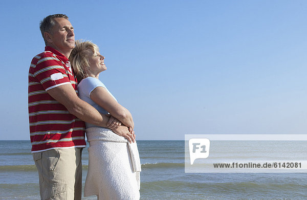 Ältere Paare umarmen sich am Strand