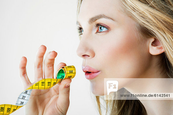 Young woman holding tape measure  close up