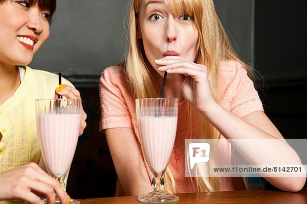 Two women drinking milkshake
