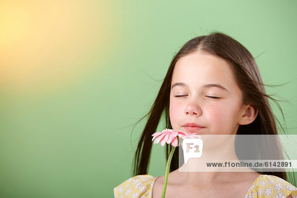 Mädchen schnüffelt Blume