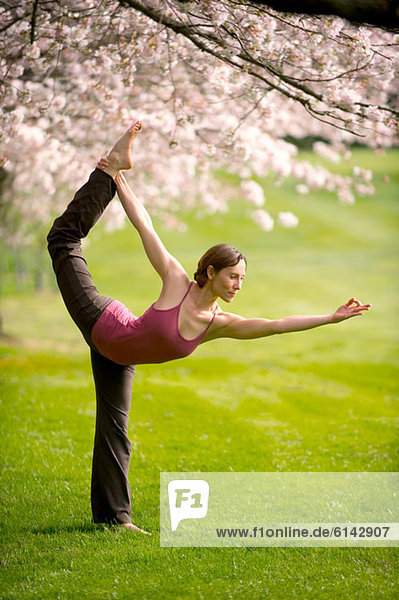 Frau in Tänzerin Yogastellung im Park