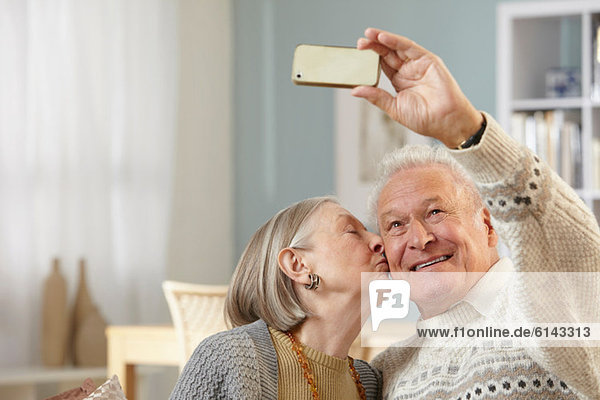 Seniorenpaar fotografiert sich mit dem Smartphone