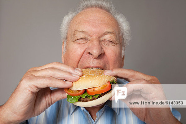 Senior Mann beim Burger essen