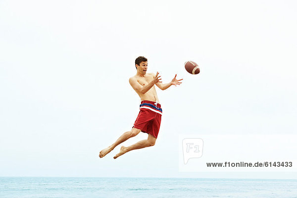 Young man catching rugby ball