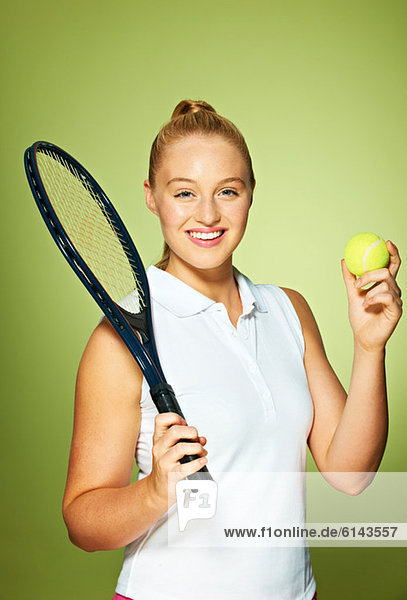 Junge Frau mit Tennisschläger und Tennisball