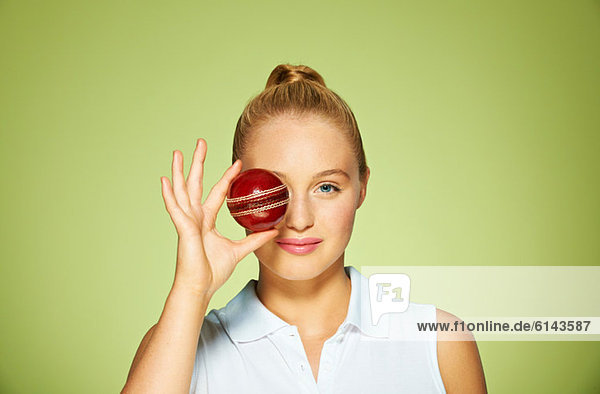 Junge Frau mit Kricketball über dem Auge