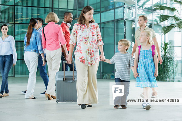 Mutter und Kinder beim Spaziergang durch den Flughafen