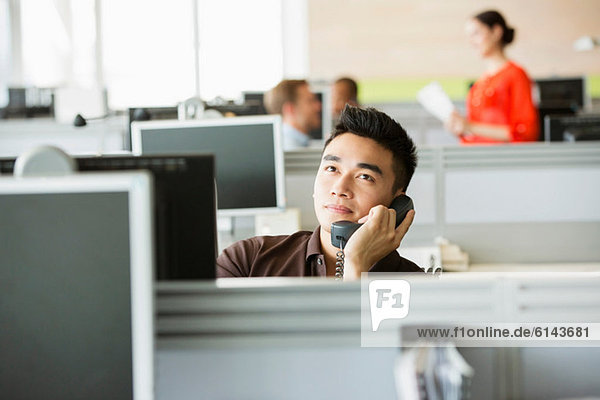 Junger Mann am Telefon im Büro