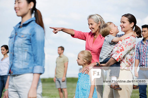 Group of people outdoors  focus on senior woman and family
