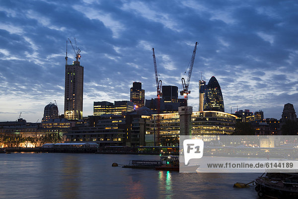 Blick auf die City of London über die Themse  mit Baustellen und Baukränen in der Abenddämmerung  London  England  Großbritannien  Europa