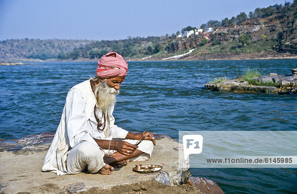 Pilger betet am Morgen am heiligen Fluss Narmada  Omkareshwar  Indien  Asien