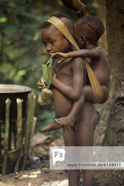 Pygmy girl carrying a young boy  Central African Republic  Africa