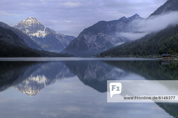 Mountains are reflected in Plansee Lake  Tyrol  Austria  Europe