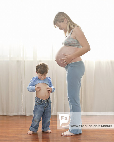 Caucasian boy imitating pregnant mother
