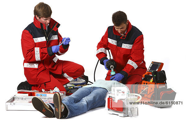 Paramedics with emergency equipment  a first aid kit with bandages  medication  a defibrillator  ECG  breathing apparatus  recuscitating a patient  professional firefighters from the Berufsfeuerwehr Essen  Essen  North Rhine-Westphalia  Germany  Europe
