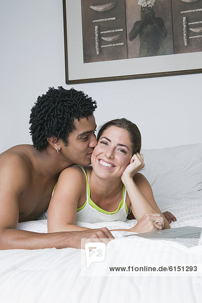 Young couple hugging on bed