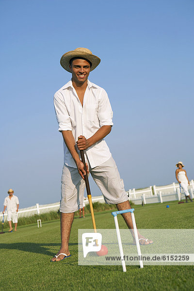 Hispanic man playing croquet