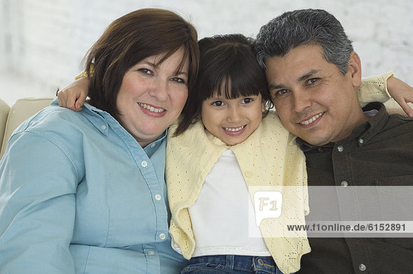 Hispanic parents and daughter hugging