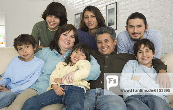 Portrait of Hispanic family on sofa