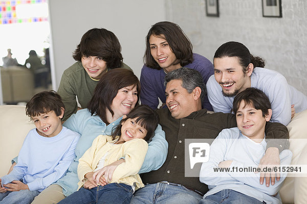 Portrait of Hispanic family on sofa