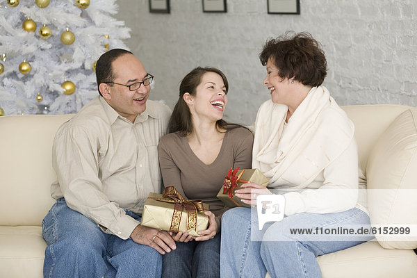 Hispanic family exchanging gifts on Christmas