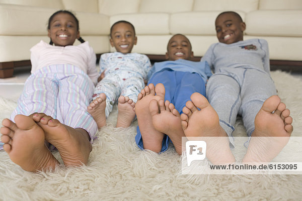 African siblings in pajamas on floor