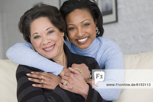 African mother and adult daughter hugging