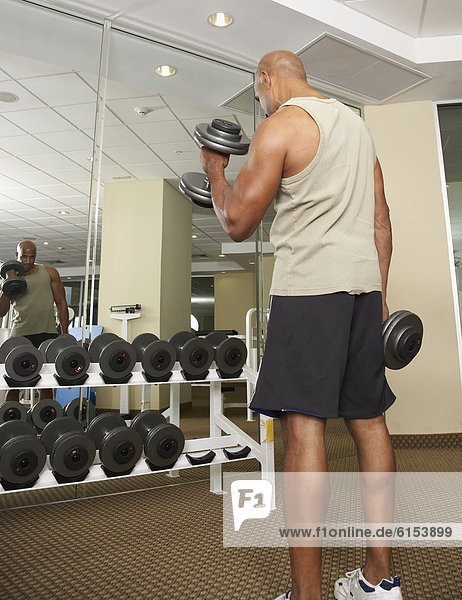 Mixed Race man lifting weights