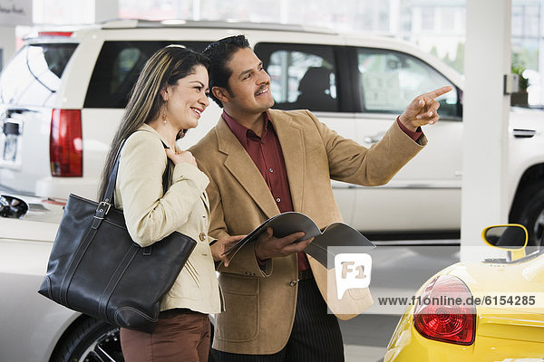 Hispanic couple at car dealership
