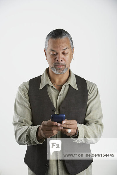Senior African man dialing cell phone