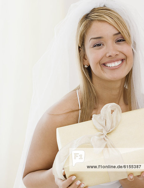 Hispanic bride holding gift