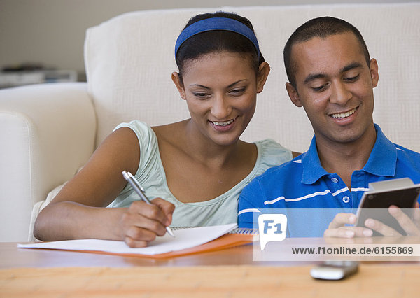 Young couple using calculator